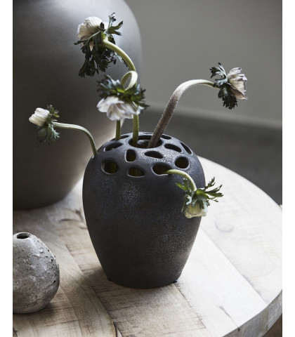 Vase med huller i toppen. Vase med rå struktur og look. Tung lertøjsvase til stillebenet
