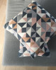 Blød og lækker sofapude. Strikket pude med triangle mønster og lækkert farvemix i rolige farver. By Lohn strikket pude.