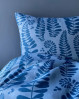 Skønt sengetøj i en rolig blå farve med et flot mønster med store bregneblade