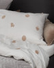 Få en skøn nats søvn i det smukke sengetøj fra Brainchild. Hvidt sengetøj med sandfarvede designikoner.