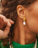 Øreringe med feminint look og et råt touch. Alua øreringe med et unikt look. Øreringe med en stor hvid ferskvandsperle hængende.