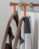 Håndklæde med skønne detaljer. Lysbrun kantbånd og orange strop og label. Mette Ditmers stilfulde håndklæde til dit badeværelse.