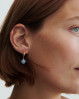 Forgyldte creoler med det fineste vedhæng med en blå sten. Blue Sky øreringe fra Pernille Corydon